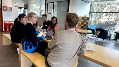 A photo of 5 of the cxpartners team sat down having a conversation