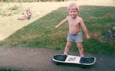 Ollie as a child on a skateboard in the garden