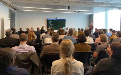 A photo of David presenting to a room full of people as part of an organisation’s customer-centred transformation programme
