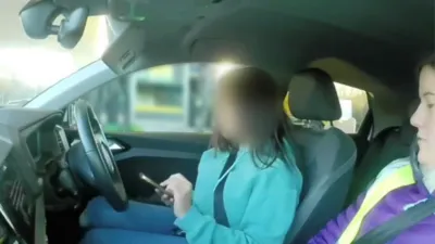 A researcher observing a driver in their car on a garage forecourt.