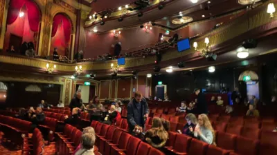 People taking to their seats in a London theatre.