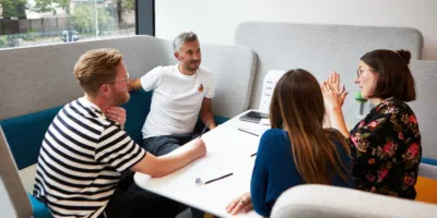 Four people sat around a table having a conversation.